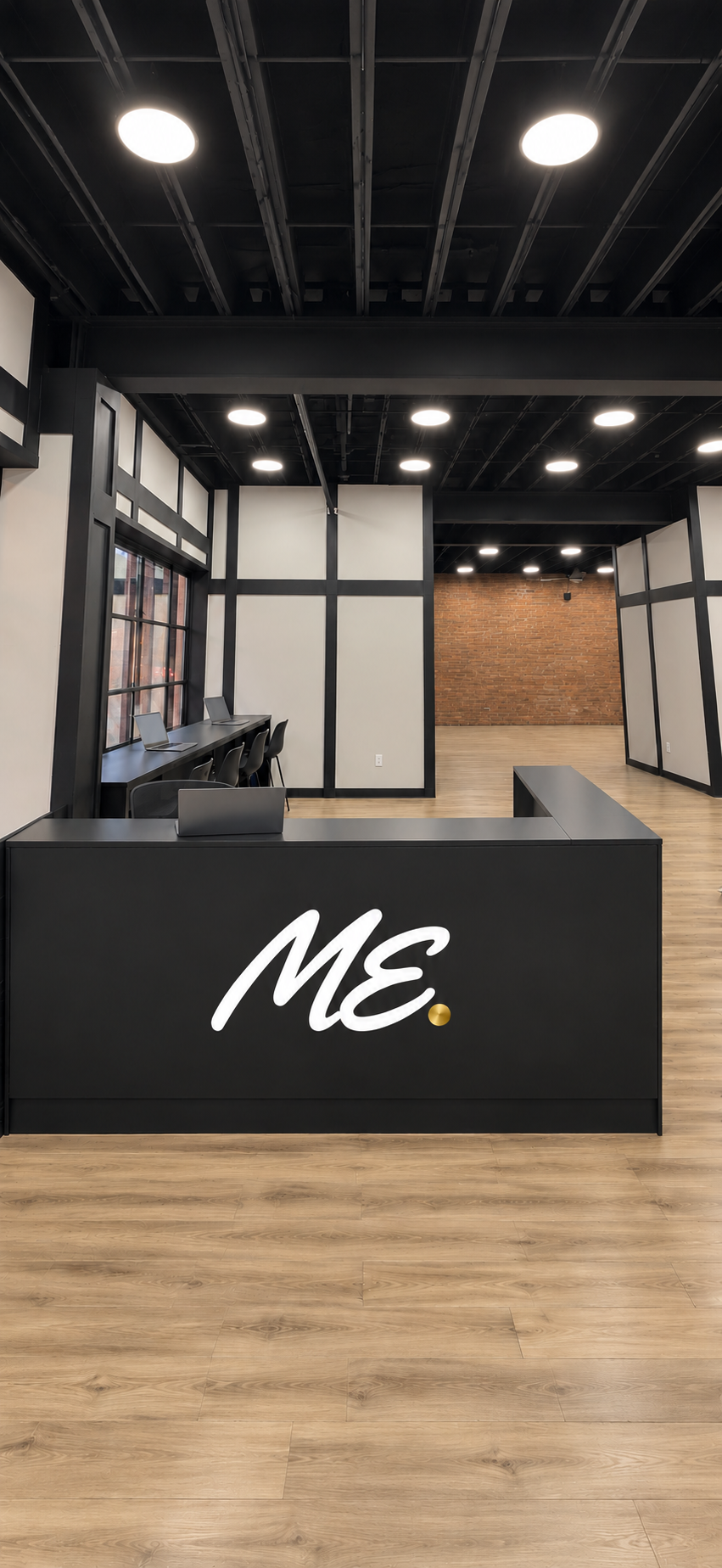 Planned black reception desk with the ME logo and a window-side counter